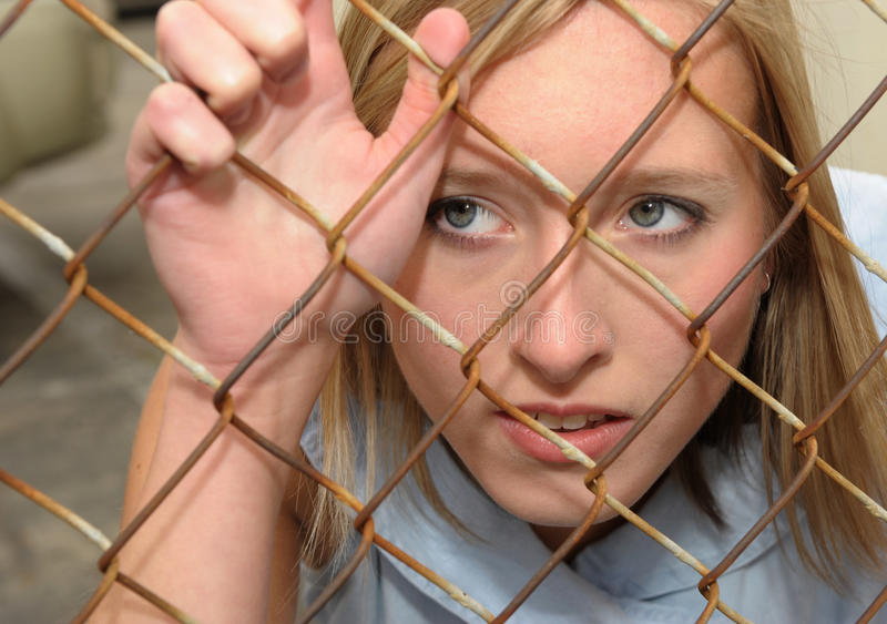 Woman peering through fence