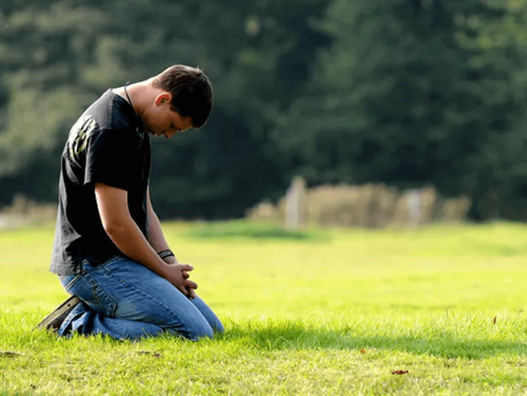 Young man kneeling in prayer